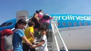 Mãe e filhos na escada do avião da aerolíneas