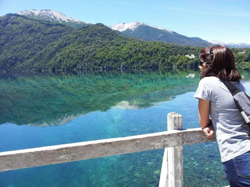 mulher observa um lago espelhado