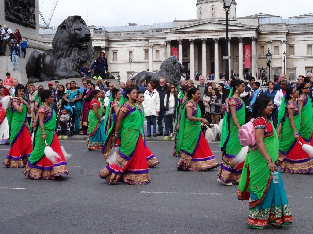 pessoas indianas com roupas coloridas desfilando em Londres
