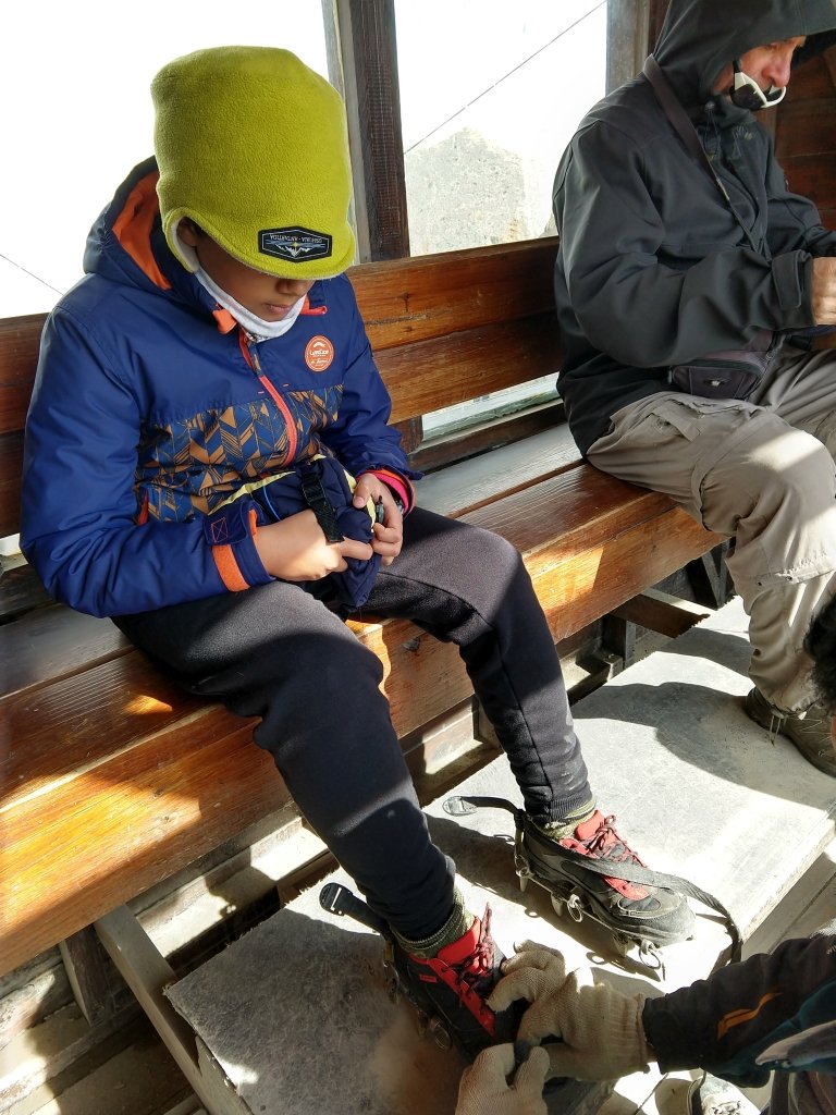 colocando grampões para fazer o mini trekking